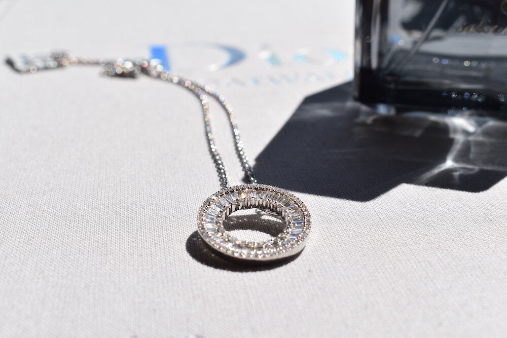 Platinum and diamond pendant featuring a baguette diamonds in a circle framed with round brilliants and a platinum chain in Dublin, London, Manchester, Ireland and the UK. Fine jewellery, engagement and wedding rings, Bridal luxury, Irish and British craftsmanship