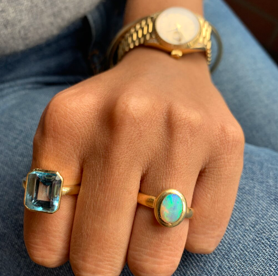 Emerald cut aquamarine and oval white opal in yellow gold rings featuring a Silhouette rubover design for dress rings or bridal in Dublin, London, Manchester, Ireland and the UK. Fine jewellery, engagement and wedding rings, Bridal luxury, Irish and British craftsmanship
