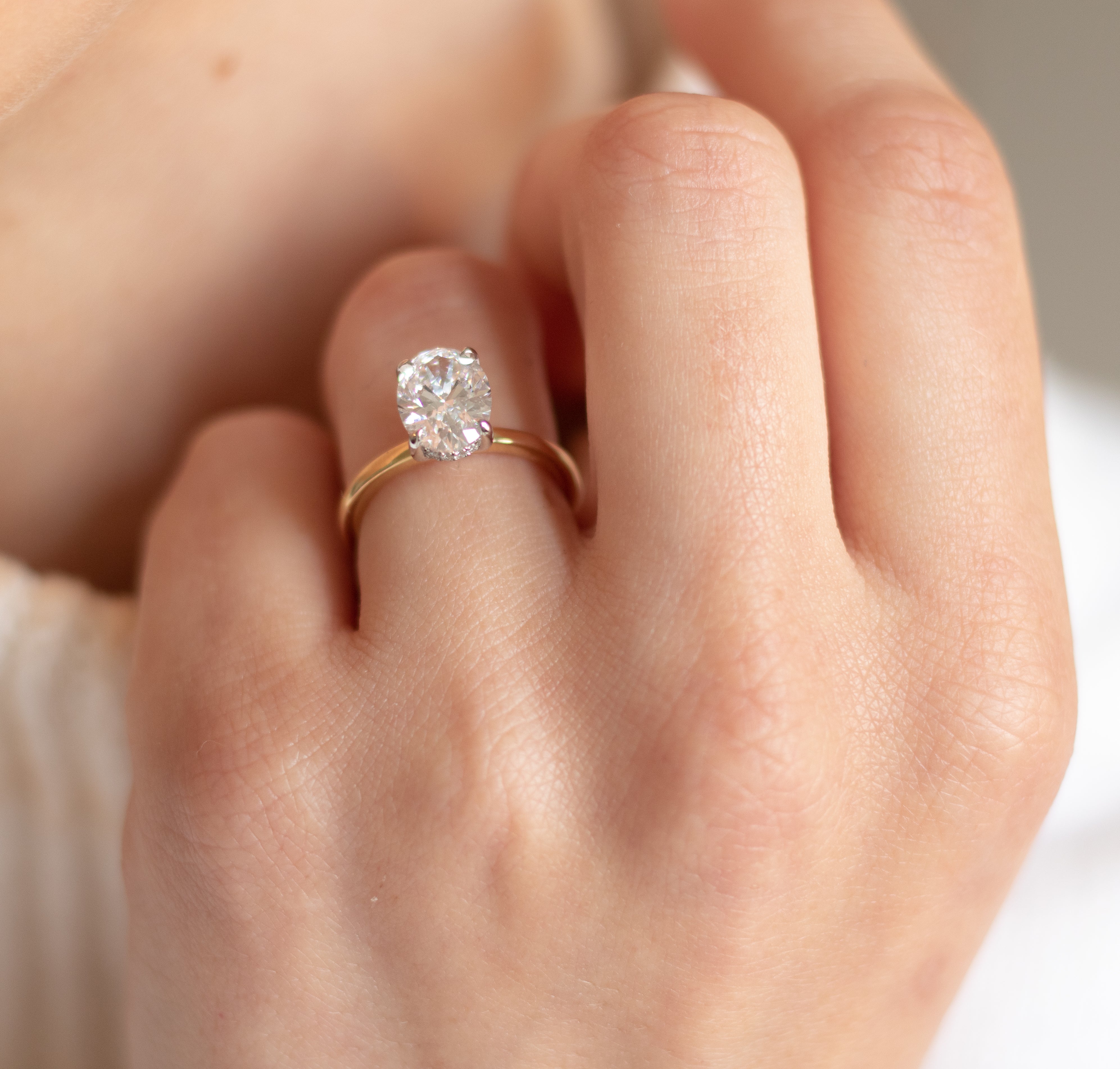 Oval diamond in 18ct yellow gold with a hidden halo as an engagement ring. Bespoke jewellery design for bridalwear, Dublin, Manchester, London jewellery