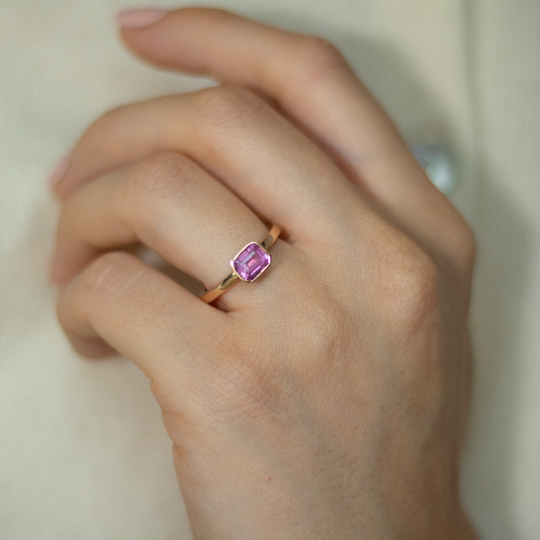 Rose gold and sapphire ring featuring a hidden halo design and emerald cut pink sapphire cut gemstone in Dublin, London, Manchester, Ireland and the UK. Fine jewellery, engagement and wedding rings, Bridal luxury, Irish and British craftsmanship