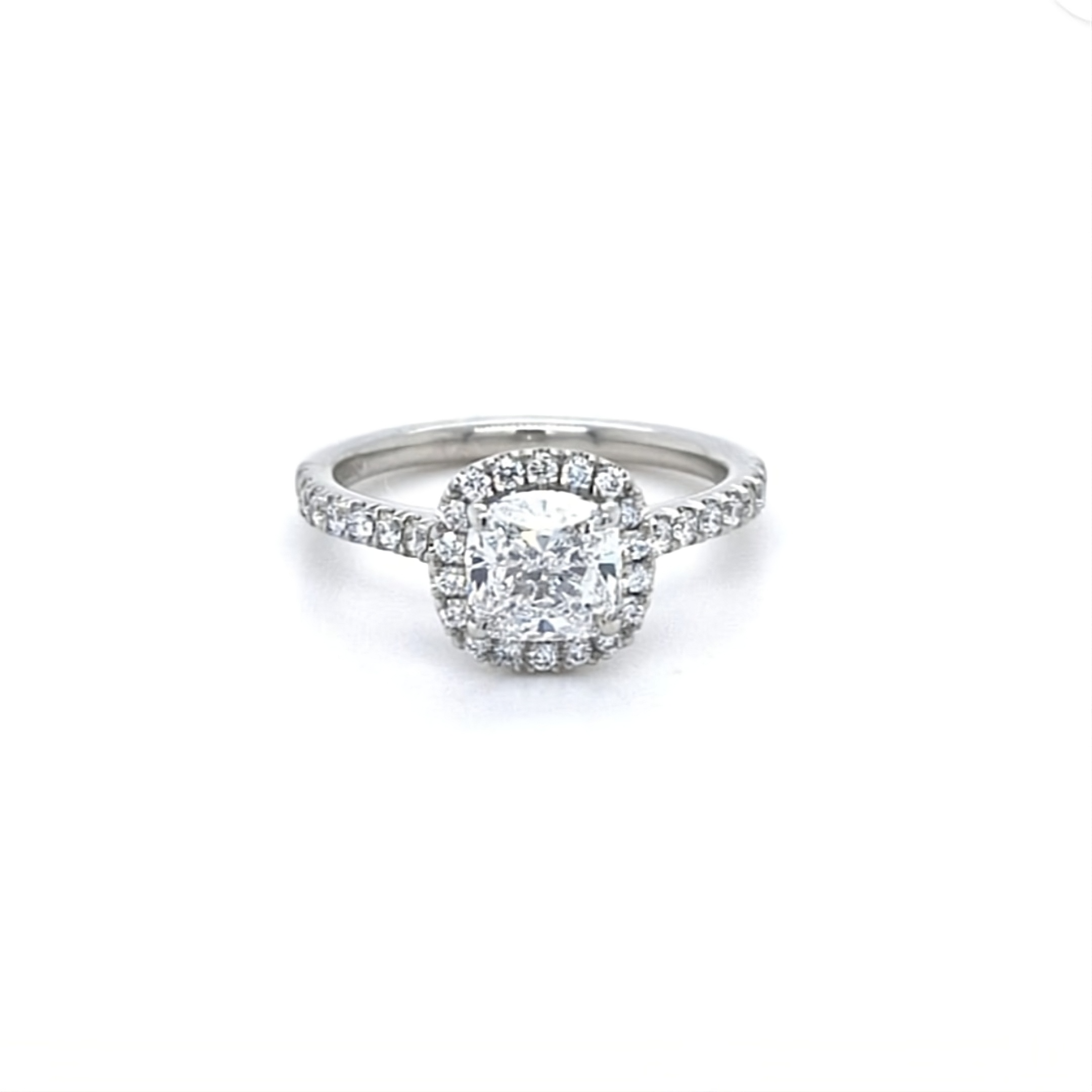 Cushion cut diamond set with a diamond halo and diamond shoulders in platinum. Handmade luxury in the UK and Ireland for engagement rings, wedding bands, eternity rings and classic jewellery.