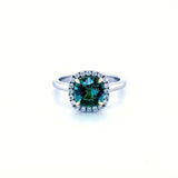 Cushion cut green tourmaline set with 18ct yellow gold claws and a diamond halo in platinum. Handmade luxury in the UK and Ireland for engagement rings, wedding bands, eternity rings and classic jewellery.