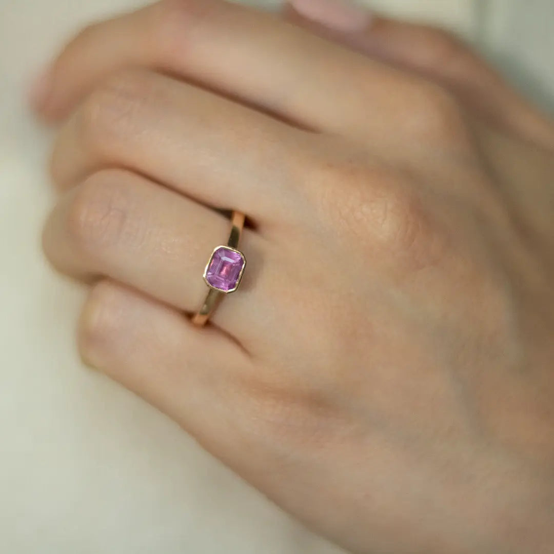 Rose gold and sapphire ring featuring a hidden halo design and emerald cut pink sapphire cut gemstone in Dublin, London, Manchester, Ireland and the UK. Fine jewellery, engagement and wedding rings, Bridal luxury, Irish and British craftsmanship