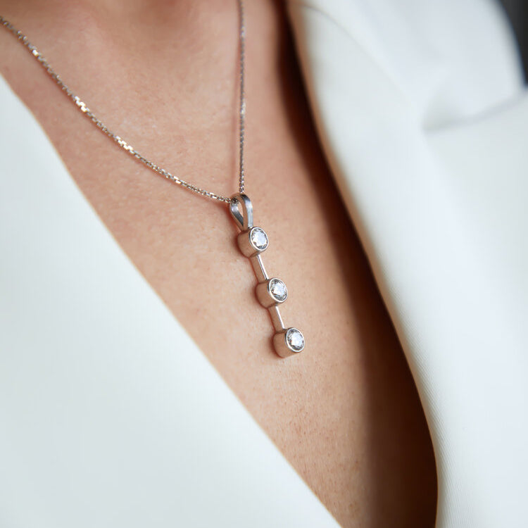 Three stone drop pendant in platinum featuring round brilliant cut diamonds in Dublin, London, Manchester, Ireland and the UK. Fine jewellery, engagement and wedding rings, Bridal luxury, Irish and British craftsmanship, timepiece