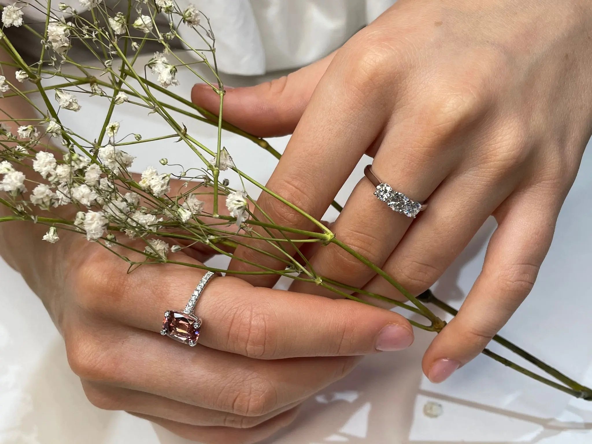 Cushion cut pink-orange tourmaline with diamond set claws, and diamond set band. Handmade luxury in the UK and Ireland for engagement rings, wedding bands, eternity rings and classic jewellery.