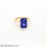 Emerald cut Tanzanite set with a talon claws in 18ct yellow gold. Handmade luxury in the UK and Ireland for engagement rings, wedding bands, eternity rings and classic jewellery.