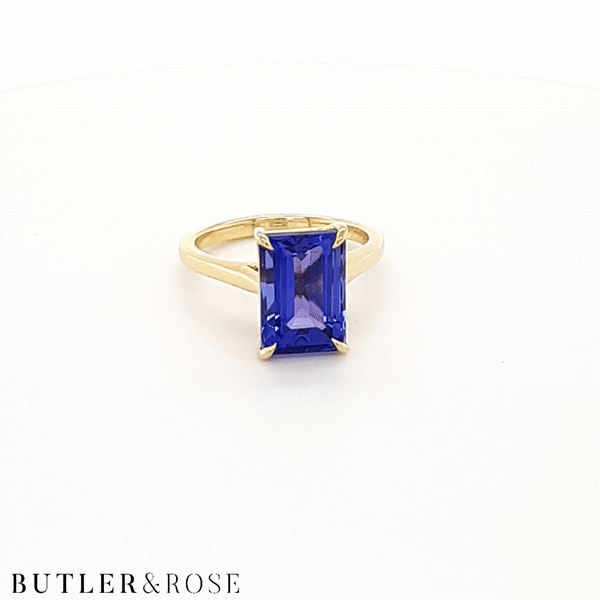 Emerald cut Tanzanite set with a talon claws in 18ct yellow gold. Handmade luxury in the UK and Ireland for engagement rings, wedding bands, eternity rings and classic jewellery.