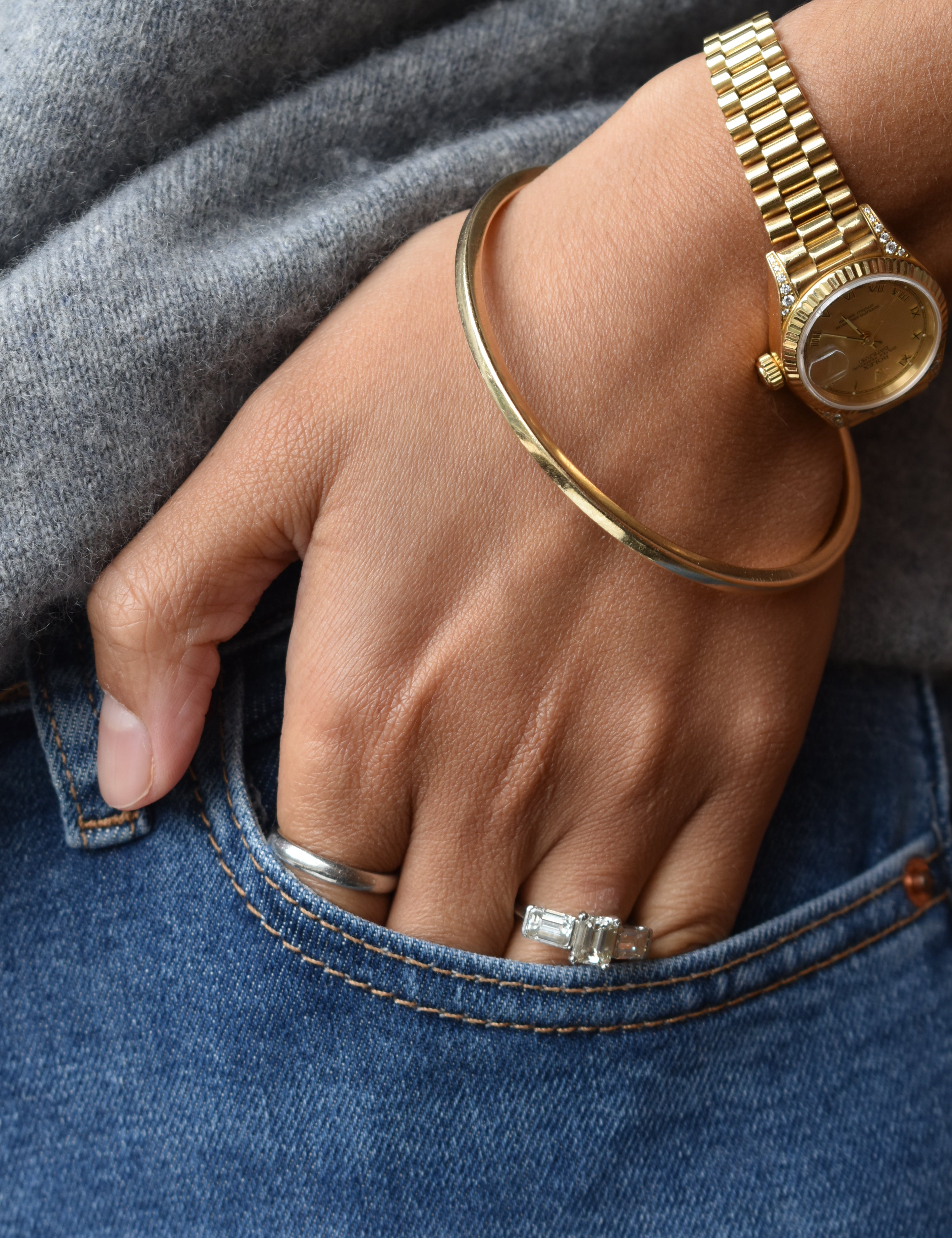 18ct yellow gold bangle featuring and engagement ring with emerald cut diamonds and a Rolex in Dublin, London, Manchester, Ireland and the UK. Fine jewellery, engagement and wedding rings, Bridal luxury, Irish and British craftsmanship, timepiece