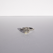 Cushion cut diamond set with a diamond halo and diamond shoulders in platinum. Handmade luxury in the UK and Ireland for engagement rings, wedding bands, eternity rings and classic jewellery.