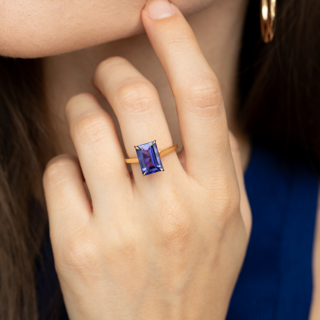 Emerald cut Tanzanite set with a talon claws in 18ct yellow gold. Handmade luxury in the UK and Ireland for engagement rings, wedding bands, eternity rings and classic jewellery.