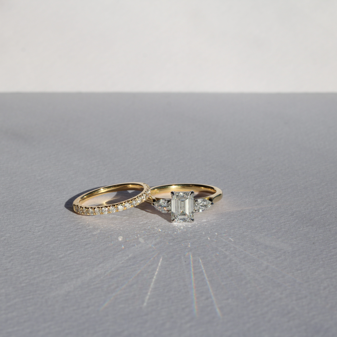 Emerald cut diamond with pear cut diamond shoulders and platinum claws and an 18ct yellow gold band. Handmade luxury in the UK and Ireland for engagement rings, wedding bands, eternity rings and classic jewellery.
