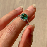 Cushion cut green tourmaline set with 18ct yellow gold claws and a diamond halo in platinum. Handmade luxury in the UK and Ireland for engagement rings, wedding bands, eternity rings and classic jewellery.