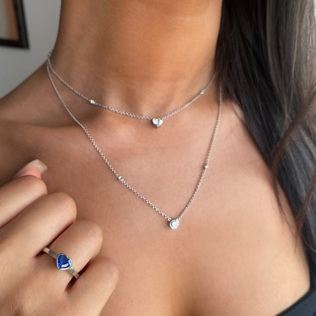 Heart shaped blue sapphire bezel set  with a hidden diamond halo in platinum. Handmade luxury in the UK and Ireland for engagement rings, wedding bands, eternity rings and classic jewellery.