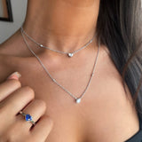 Heart shaped blue sapphire bezel set  with a hidden diamond halo in platinum. Handmade luxury in the UK and Ireland for engagement rings, wedding bands, eternity rings and classic jewellery.
