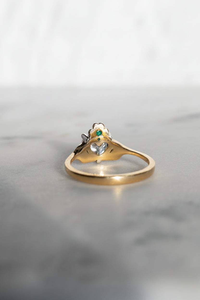 Hidden green emerald, behind a shamrock crown on the butler and rose Claddagh ring in 18ct yellow gold.