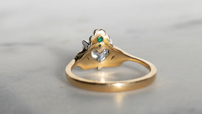 Hidden green emerald, behind a shamrock crown on the butler and rose Claddagh ring in 18ct yellow gold.