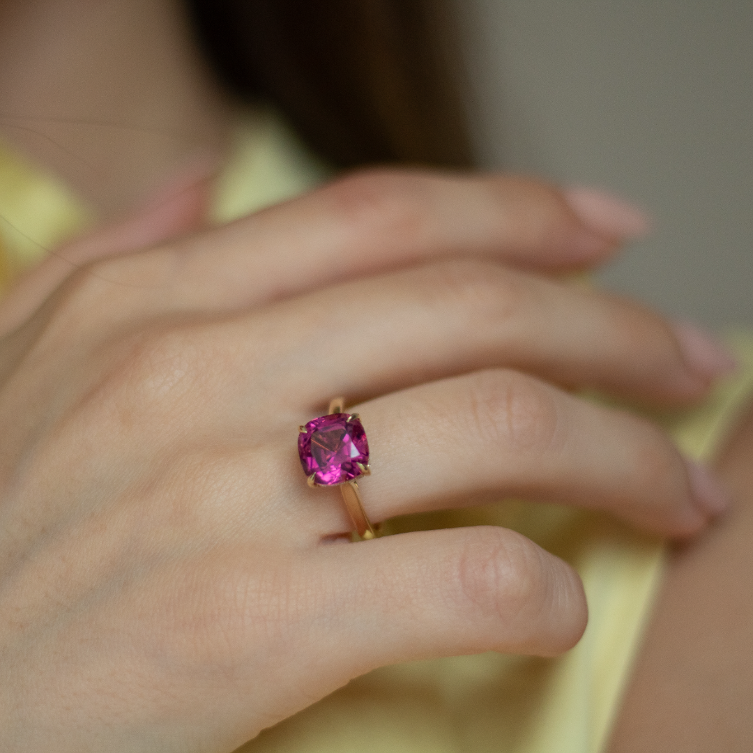 Cushion cut pink tourmaline set with a hidden halo in 18ct rose gold. Handmade luxury in the UK and Ireland for engagement rings, wedding bands, eternity rings and classic jewellery.