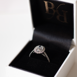 Oval cut diamond in a platinum Royal design with a halo of diamonds and diamond set band in platinum with talon claws. Handmade luxury in the UK and Ireland for engagement rings, wedding bands, eternity rings and classic jewellery.