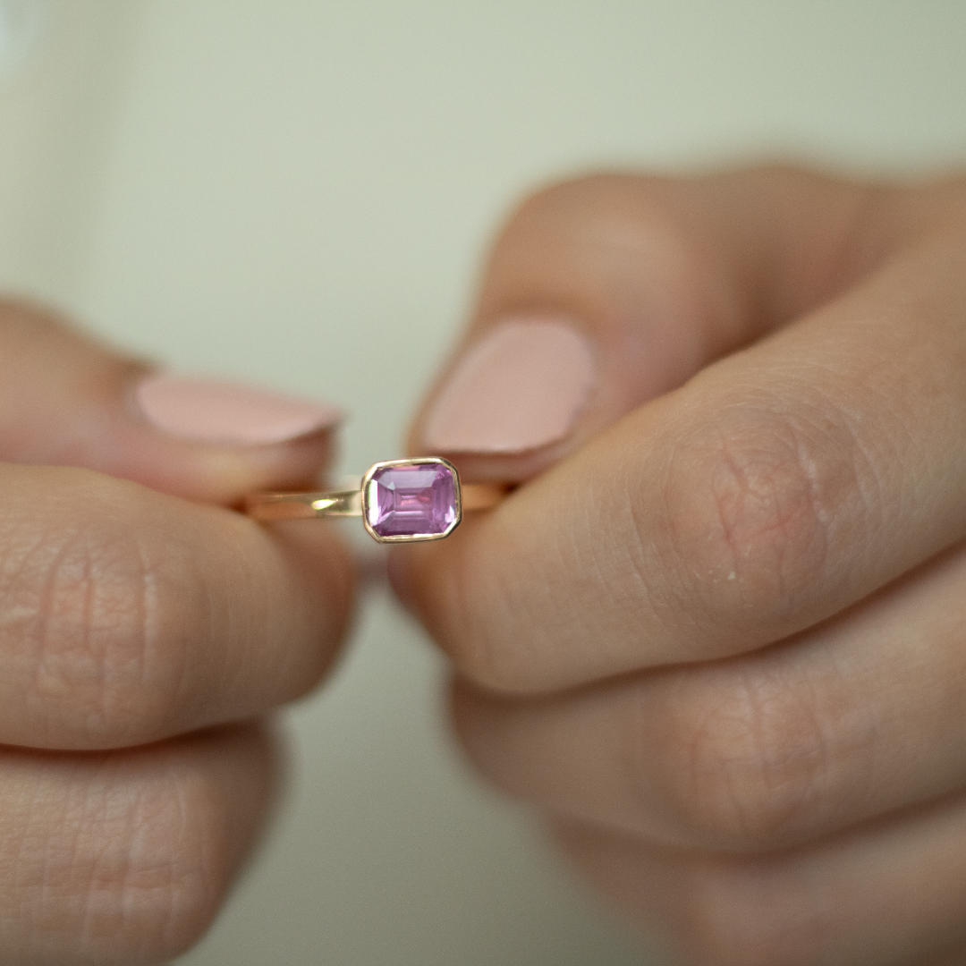 Rose gold and sapphire ring featuring a hidden halo design and emerald cut pink sapphire cut gemstone in Dublin, London, Manchester, Ireland and the UK. Fine jewellery, engagement and wedding rings, Bridal luxury, Irish and British craftsmanship