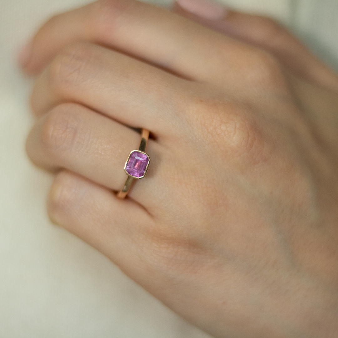 Rose gold and sapphire ring featuring a hidden halo design and emerald cut pink sapphire cut gemstone in Dublin, London, Manchester, Ireland and the UK. Fine jewellery, engagement and wedding rings, Bridal luxury, Irish and British craftsmanship