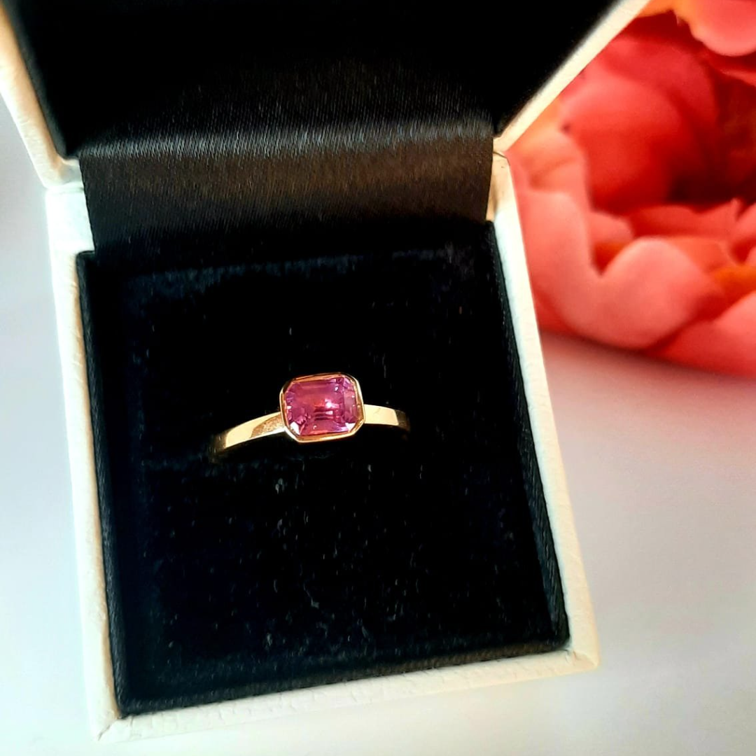 Rose gold and sapphire ring featuring a hidden halo design and emerald cut pink sapphire cut gemstone in Dublin, London, Manchester, Ireland and the UK. Fine jewellery, engagement and wedding rings, Bridal luxury, Irish and British craftsmanship