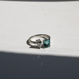 Toi et Moi with a green cushion cut tourmaline and pear cut diamond with platinum claws on a platinum band. Handmade luxury in the UK and Ireland for engagement rings, wedding bands, eternity rings and classic jewellery.