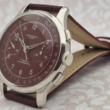 Vintage wristwatch with wine strap and detailed face on a light background