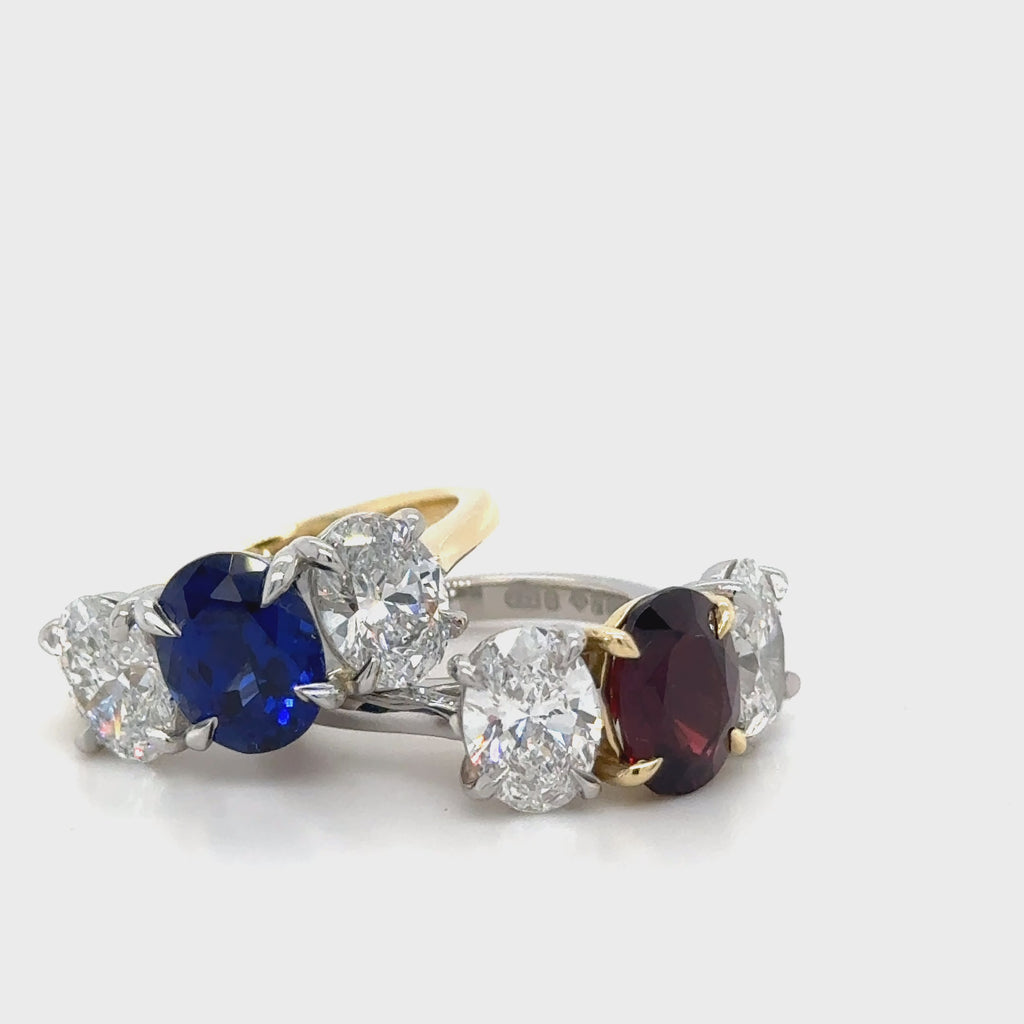 Butler & Rose handmade 3 stone garnet and oval cut diamond trilogy ring in platinum with talon claws perfect for an engagement or anniversary ring. fine quality and luxury details make this a classic