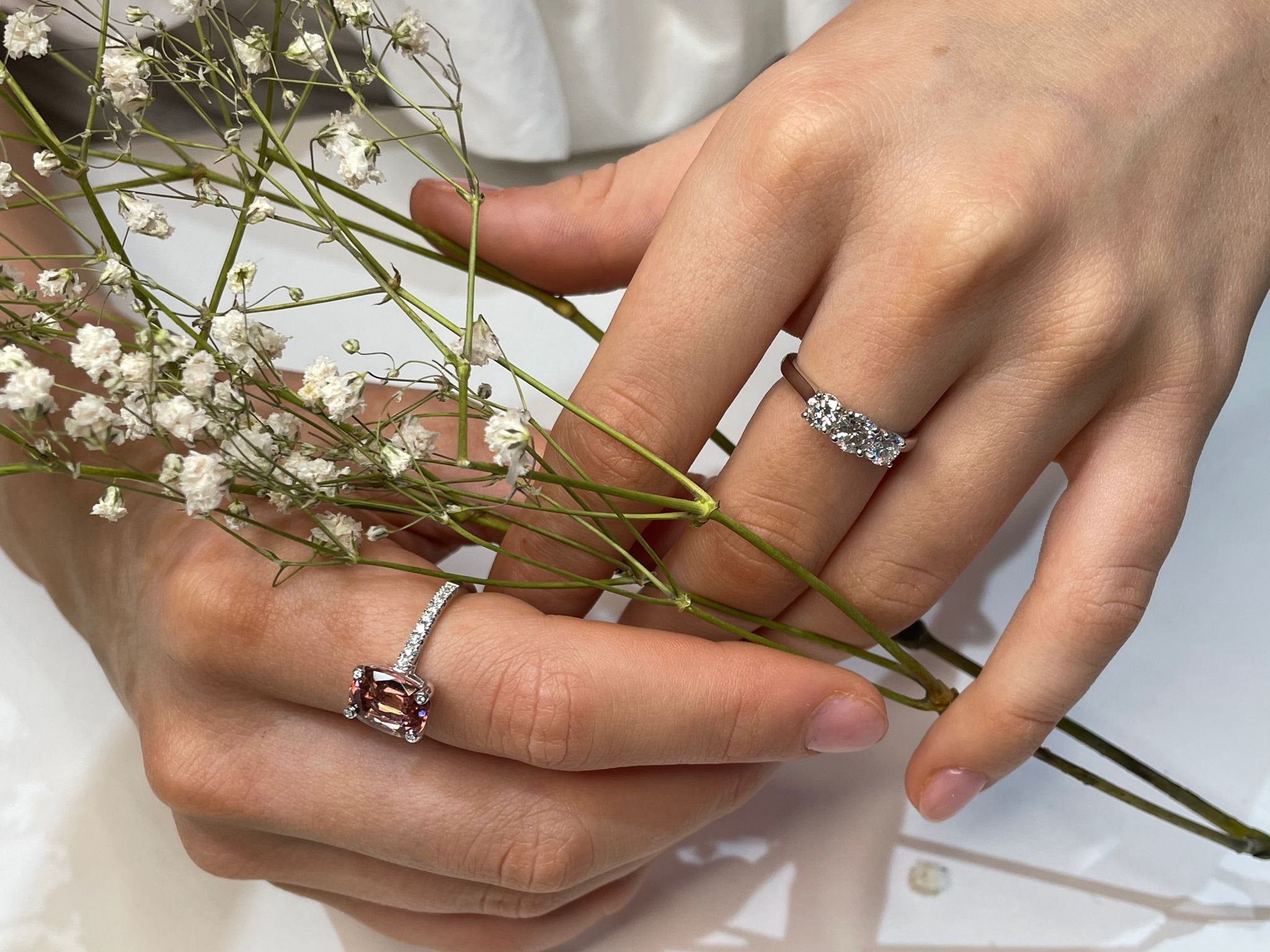 Cushion cut pink-orange tourmaline with diamond set claws, and diamond set band. Handmade luxury in the UK and Ireland for engagement rings, wedding bands, eternity rings and classic jewellery.